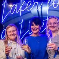 President Mantella poses with two grads in front of the Laker for a Lifetime sign